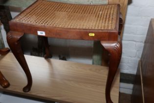 A 1930s carved walnut dressing stool with cane seat, on cabriole supports, 24" wide x 16" deep x 20"