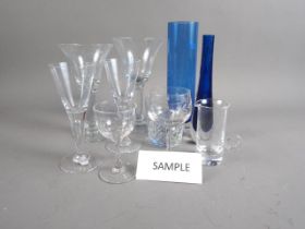A set of nine clear glass goblets, a smaller matching set of six goblets, three tumblers, three blue