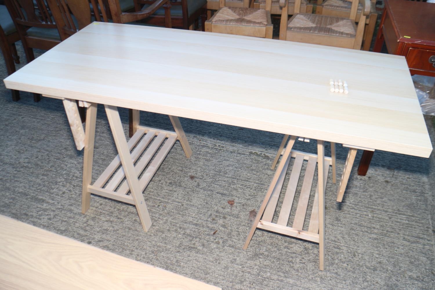 A modern laminate top adjustable height table, on trestle supports, 54" wide x 24" deep x 32" high