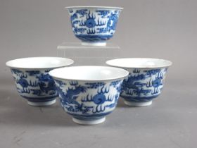 A set of four Chinese porcelain blue and white bowls with flared rims, decorated dragons and clouds,