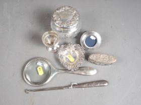 Two cut glass silver mounted dressing table jars, a silver magnifying glass, a silver egg cup, a