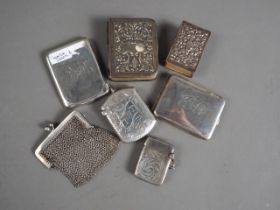 Two silver vesta cases, two silver matchbook holders, a silver matchbox sleeve, a white metal mesh