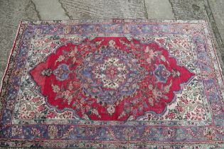 A Persian Nadjaffabad carpet of traditional design, on a red ground, 138" x 98" approx
