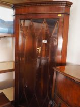 A mahogany bowfront corner cabinet in two sections, with diamond lattice glazed top over cupboard