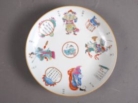 A Chinese porcelain polychrome enamel decorated dish with figures and verses, 9" dia