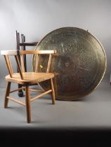 A circular brass topped folding table, a child's elm and beech stick back chair, and a carved oak