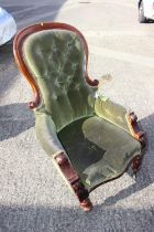 A mid Victorian walnut showframe armchair, button upholstered in a green velour, on cabriole