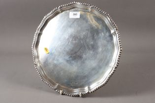 A silver pie crust salver, raised on three ball and claw supports, 27.5oz troy approx