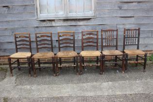 A set of four oak ladder back dining chairs with rush seats, and a similar matched pair of spindle