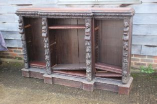 A late Victorian carved oak breakfront open bookcase of early 17th century design, fitted adjustable