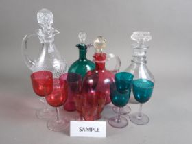 A Georgian cut glass three-ring neck decanter, two other glass decanters, a glass carafe, a green