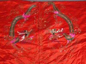 An early 20th century Chinese embroidered panel with dragon design on a red ground