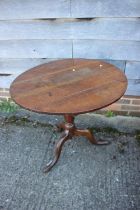 An 18th century oak circular top occasional table, on turned column and tripod splay support, 32"