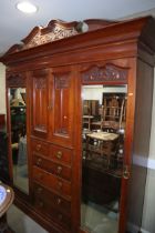 An early 20th century Maple & Co carved walnut wardrobe, fitted cupboard over two short and four