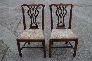 A pair of 18th century mahogany standard dining chairs of Chippendale design with drop-in seats,