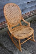 An oak rocking chair with cane seat and back panels