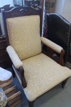 A pair of Edwardian carved walnut open armchairs, upholstered in a cream scroll figured fabric, on