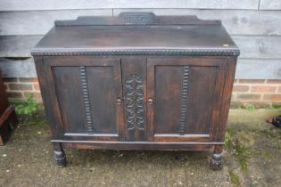 A 1930s ebonised ledge back sideboard, enclosed two doors, on turned and stretchered supports, 41"