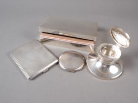 A silver cigarette box, a silver capstan inkwell, an engine turned silver cigarette case and a