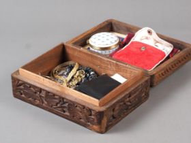 A carved wooden box containing a selection of costume and other jewellery, including a pearl