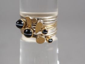 Wendy Ramshaw: an eight-section yellow and white metal stacking ring, set polished agate