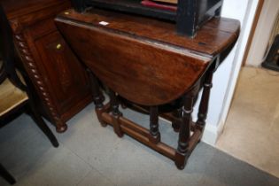 An oak oval drop leaf gate leg table, on turned and stretchered supports, 30" wide x 36" deep x