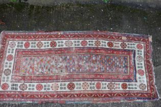 An antique Caucasian rug with floral centre on a purple ground, 88" x 40" approx and another with