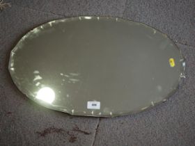 A 1950s oval wall mirror, 22" high