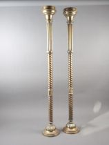 A pair of brass ecclesiastical candlesticks with spiral turned columns and circular bases, 36" high