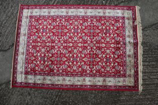 A Kashmir carpet with floral motifs, on a red ground with gold border, 67" x 47" approx