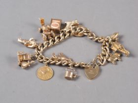 A 9ct gold curb link charm bracelet with heart-shaped clasp and ten various charms, 70.5g