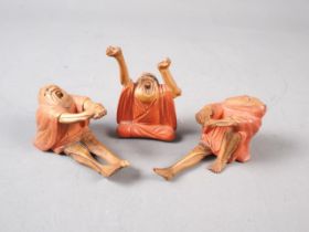 A set of three Japanese carved and painted wood figures, The Awakening of Daruma, 2 1/2" high (one