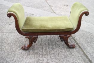 A Regency carved rosewood window seat with scroll ends, upholstered in a green velour, on lion paw