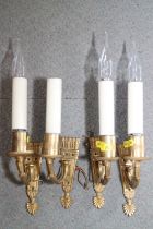 A set of four gilt brass single light wall brackets with quiver back plates and faux candles, 14"