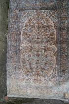 A Persian Kashan silk pile rug with all-over floral design, on a pink ground and multi-borders in