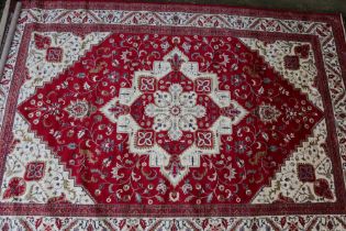 A Kashmir full pile carpet with floral design, on a red ground, 118" x 78" approx