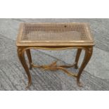 A carved giltwood stool with cane panel seat, on cabriole supports (stretcher for repair), and a