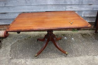 A late Georgian mahogany and rosewood banded rectangular tilt top breakfast table, on turned