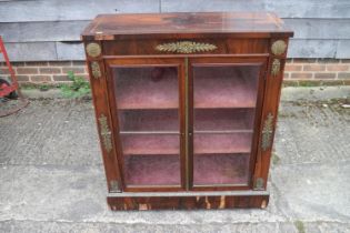 A mid 19th century rosewood, brass line inlaid and gilt brass mounted pier cabinet enclosed two