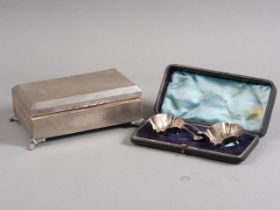 A silver engine turned cigarette box and a pair of silver salts and spoons, in case