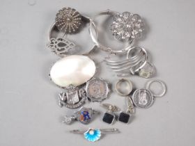 Two silver bangles, a white metal eternity ring, set paste stones, a number of silver brooches,