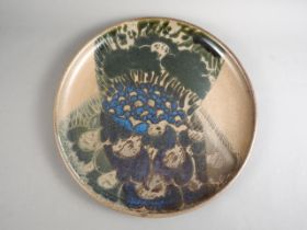 A 1960s studio pottery charger with blue mottled tree design, 22" dia