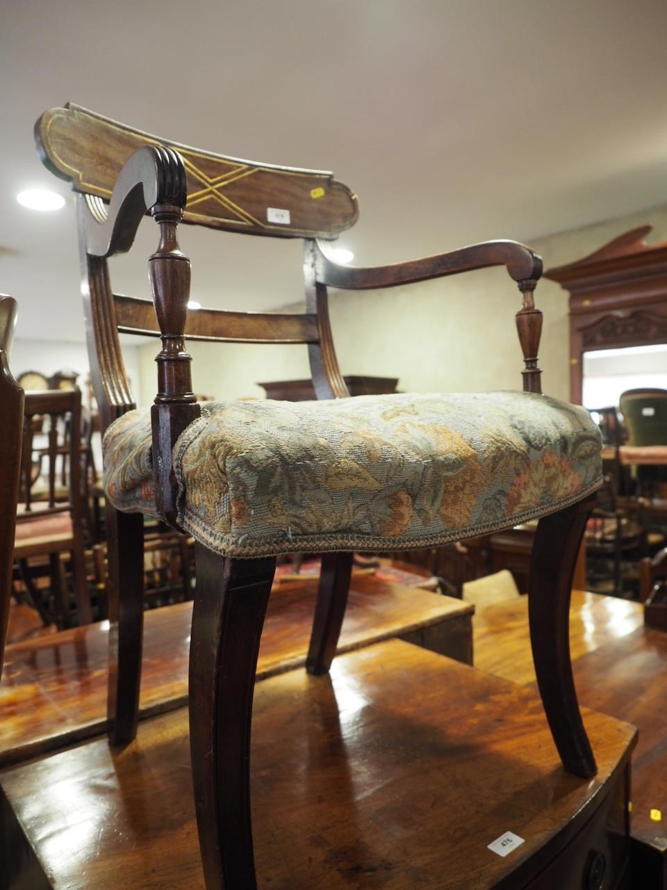 A Regency mahogany and brass inlaid bar back carver dining chair with stuffed over seat, on sabre