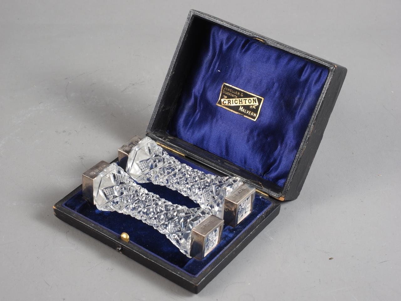 A pair of cut glass and silver mounted knife rests, in fitted box