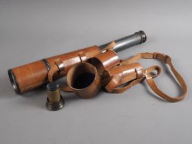 An officer's WWI three-draw telescope, in leather case  with additional optics