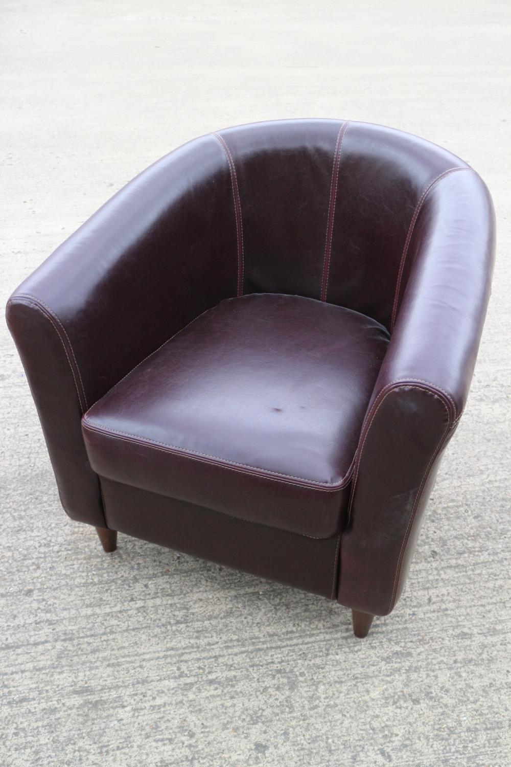 A dark brown leather tub seat armchair, on turned supports