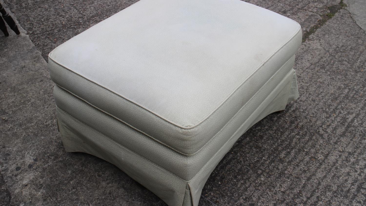 An ottoman, upholstered in a light green linen, on square taper supports, 26" wide x 31" deep x
