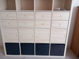 An Ikea Kallax storage unit with numerous drawers, 55" wide x 15" deep x 57" high (for home