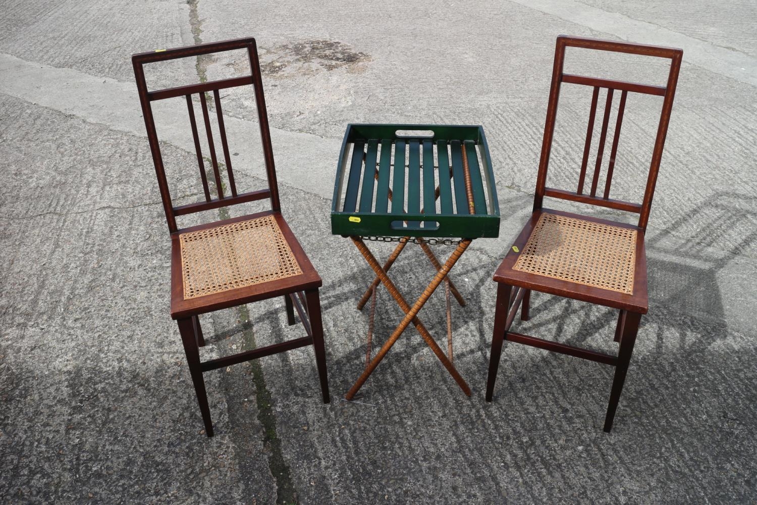 A pair of Edwardian mahogany and inlaid cane seat bedroom chairs and a folding tray, on a stand