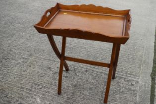 A polished as walnut tray, on folding stand, 26" long x 16" deep x 28" high, and a polished as
